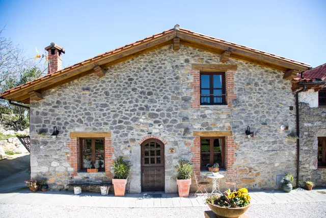 Elegante fachada de casa rural de piedra con detalles en ladrillo en Las Merindades